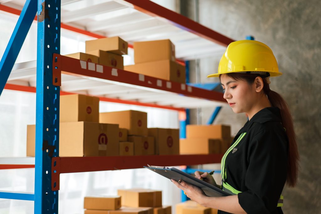 Logistic workers are checking and preparing the product parcel cardboard box in warehouse.